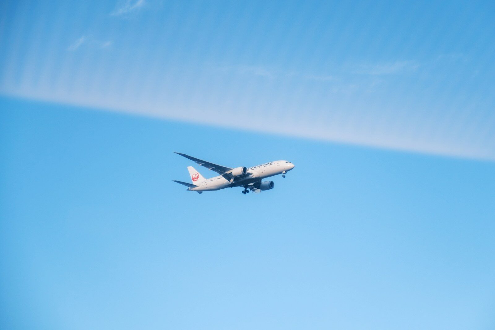 An airplane is flying in the blue sky